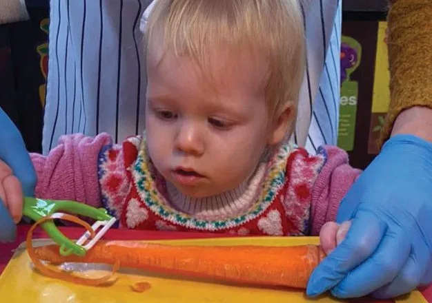 Child exploring materials at a classroom activity table