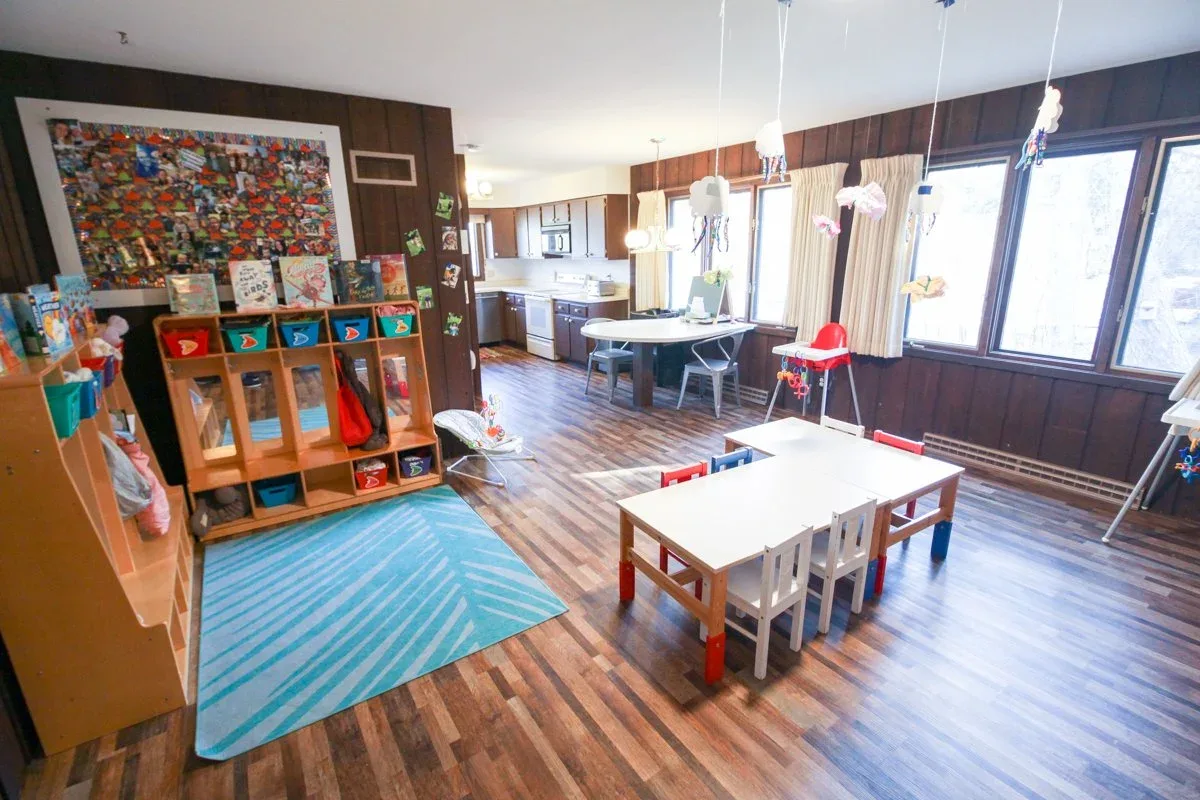 Applewood playroom with a low table, toy shelves, and wide windows at BBDS Applewood Drive, Madison, WI