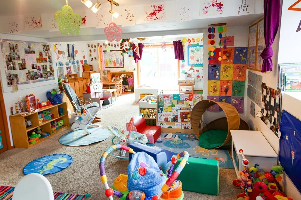 Morraine View playroom with a tunnel, floor mats, and shelves of toys at BBDS Morraine View, Madison, WI