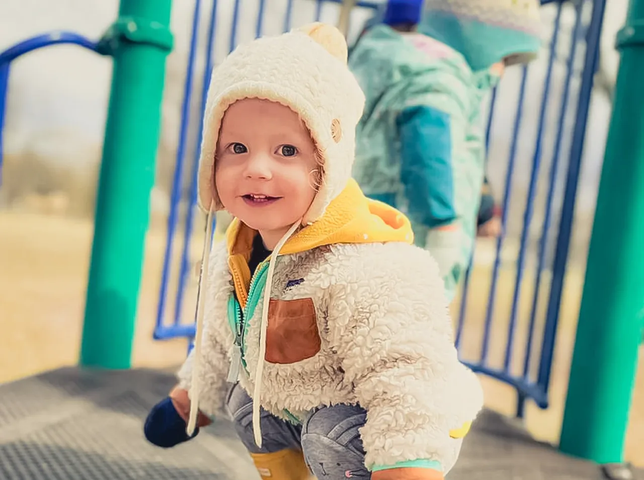 Child playing on outdoor climbing equipment