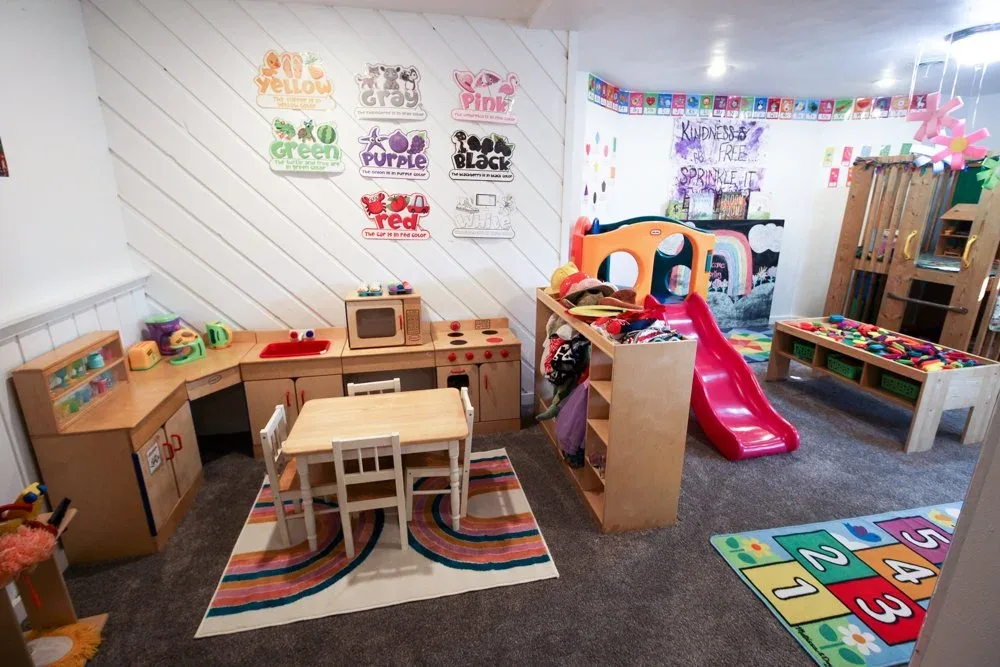 Pretend-play kitchen and a small slide with learning displays
