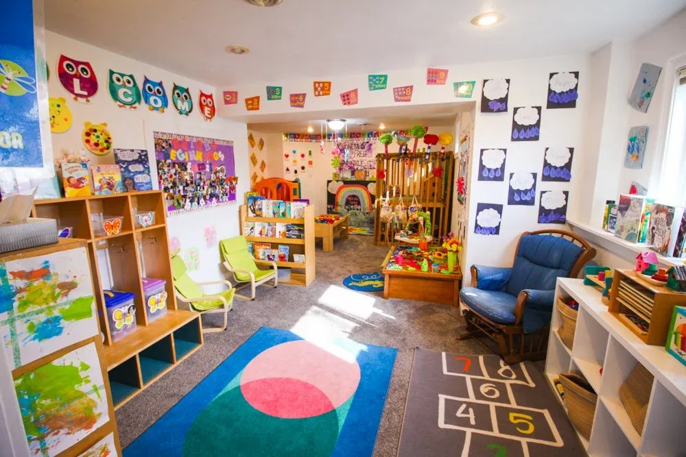 Playroom with bookshelves, child-sized furniture, and rugs