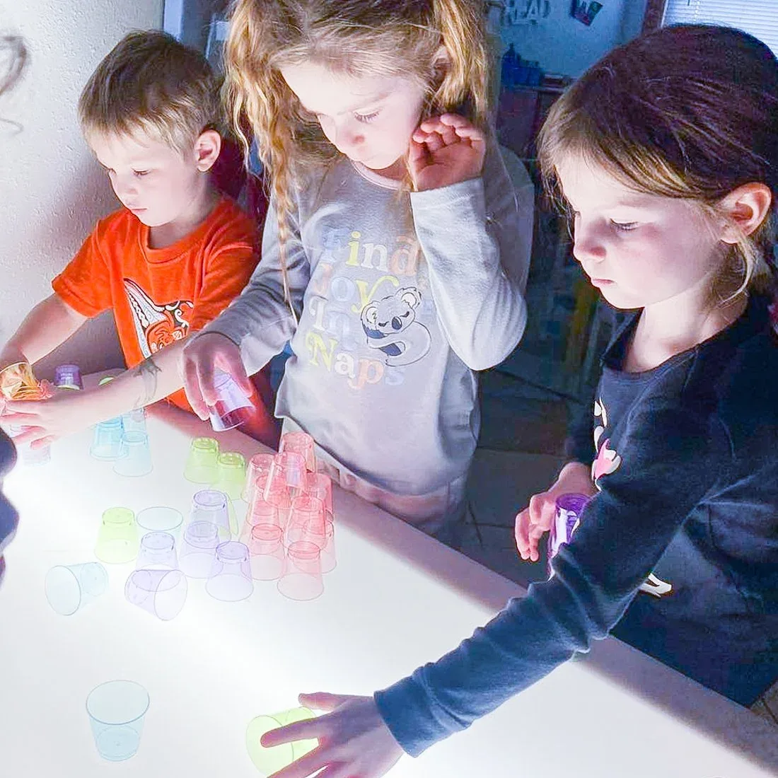 Colorful translucent cups arranged on a classroom light table