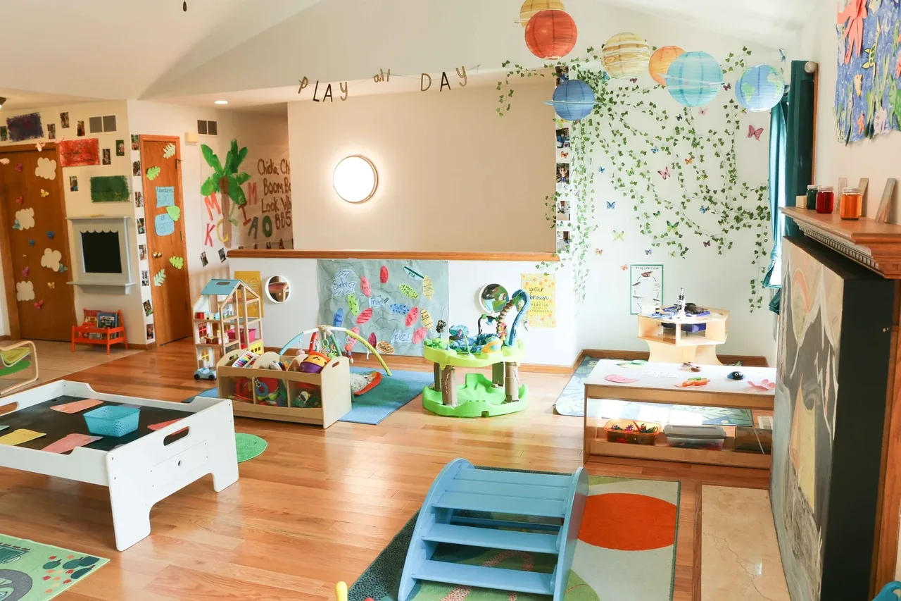 Castle Pines playroom with a small slide, rugs, and a low activity table at BBDS Castle Pines, Madison, WI