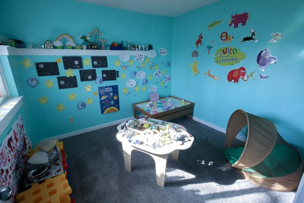 Blue-walled playroom with a sensory table
