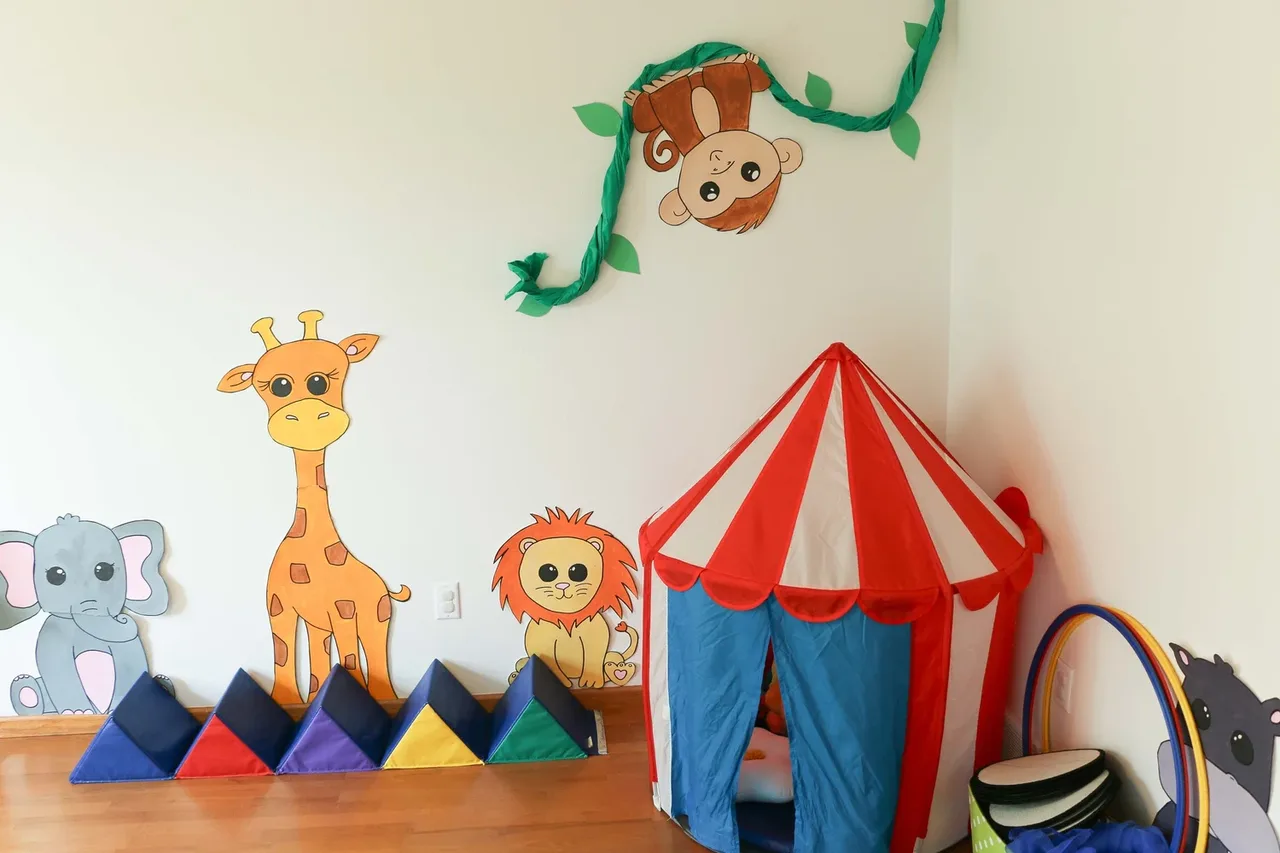 Castle Pines playroom with a circus-themed tent and animal wall art at BBDS Castle Pines, Madison, WI