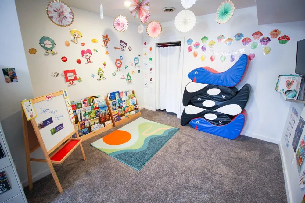 Reading corner with books, a soft rug, and cozy seating