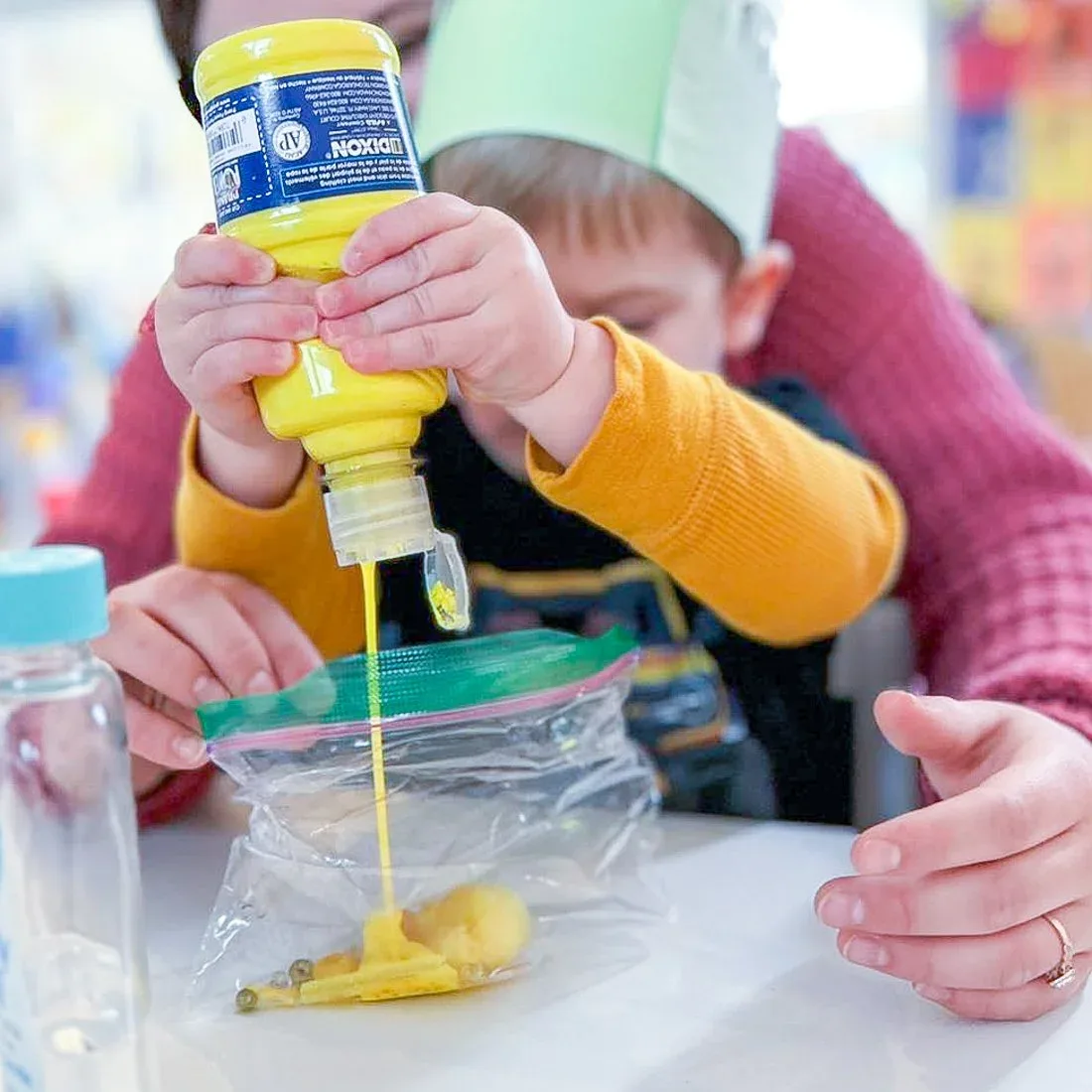 A child squeezing paint during an art activity