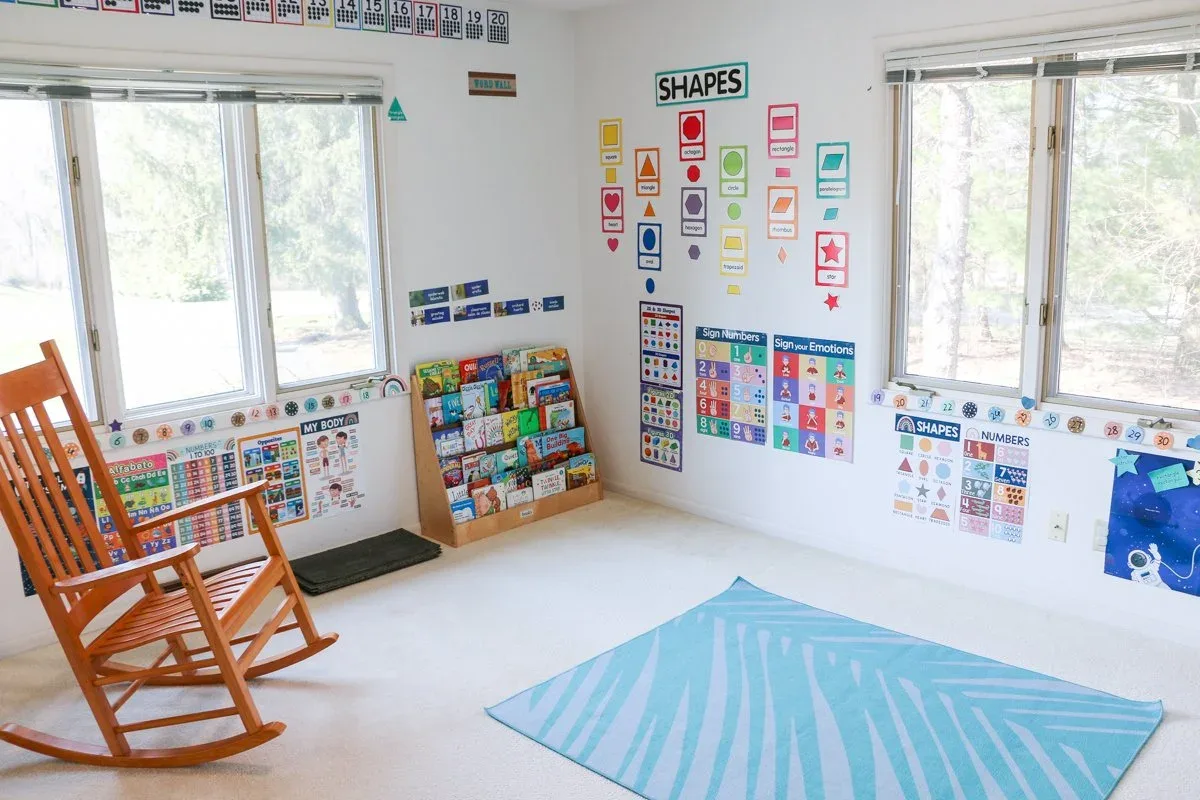 Applewood reading area with a rocking chair, book shelves, and a blue rug at BBDS Applewood Drive, Madison, WI